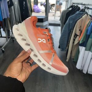 On Running Orange and White Athletic Shoes with Lace-Up Closure